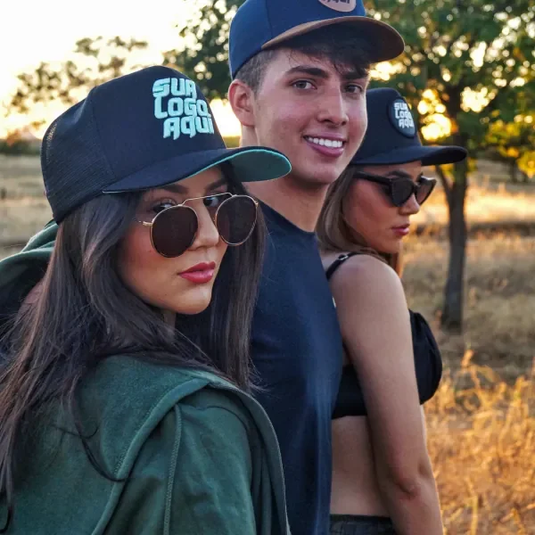 Grupo de jovens com bonés escuros e logo turquesa personalizada ao pôr do sol